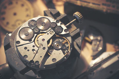 Watch mechanism recording: close-up of watch gears and parts on a workbench.